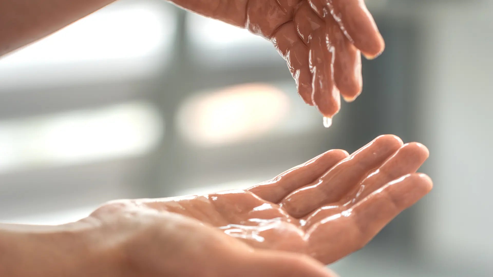Woman applying body oil to damp skin right after shower as part of a simple non-greasy evening body care routine